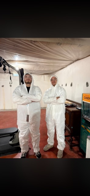 Sanchez Junk & Haul crew in protective suits before an insulation rip-out in Flat Rock, MI