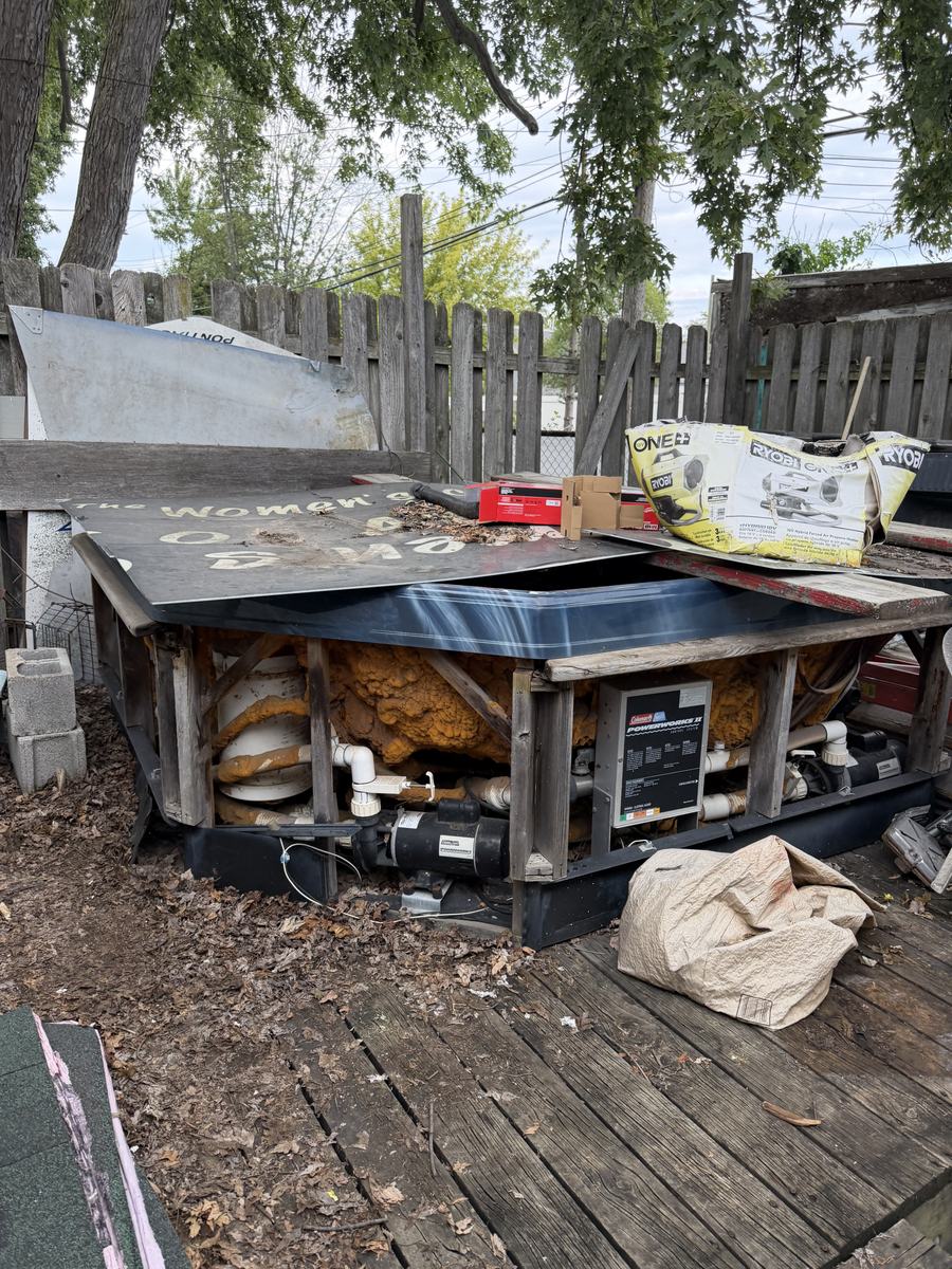 Old hot tub sitting on a backyard deck in Taylor, MI, before removal