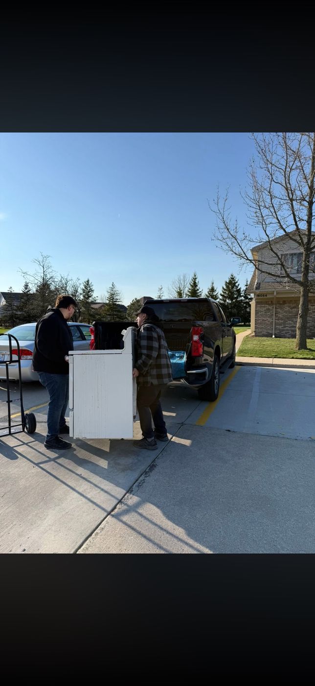 Sanchez Junk & Haul crew bringing an old appliance to the truck in Southgate, MI